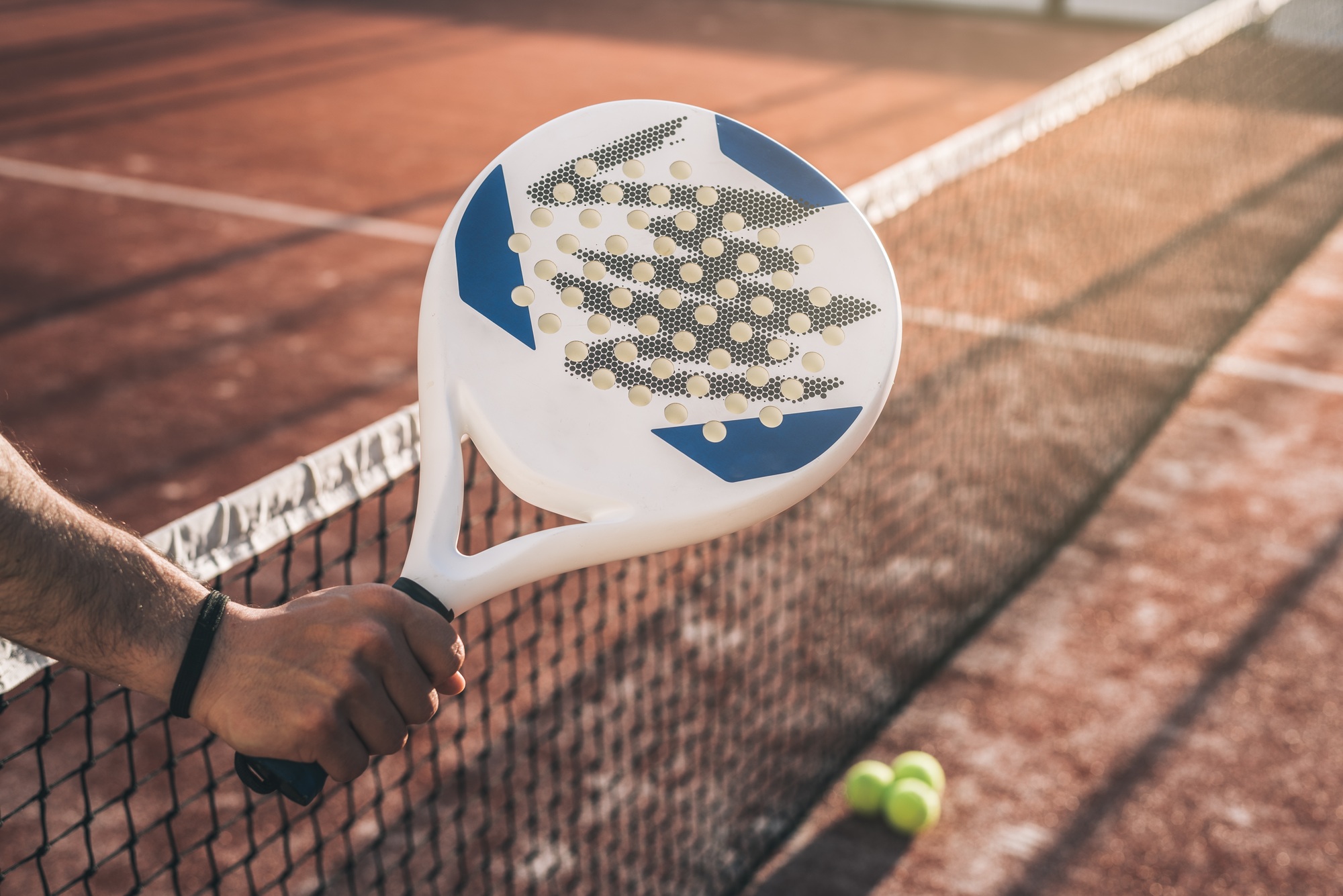 Man hand grabbing a padel racket