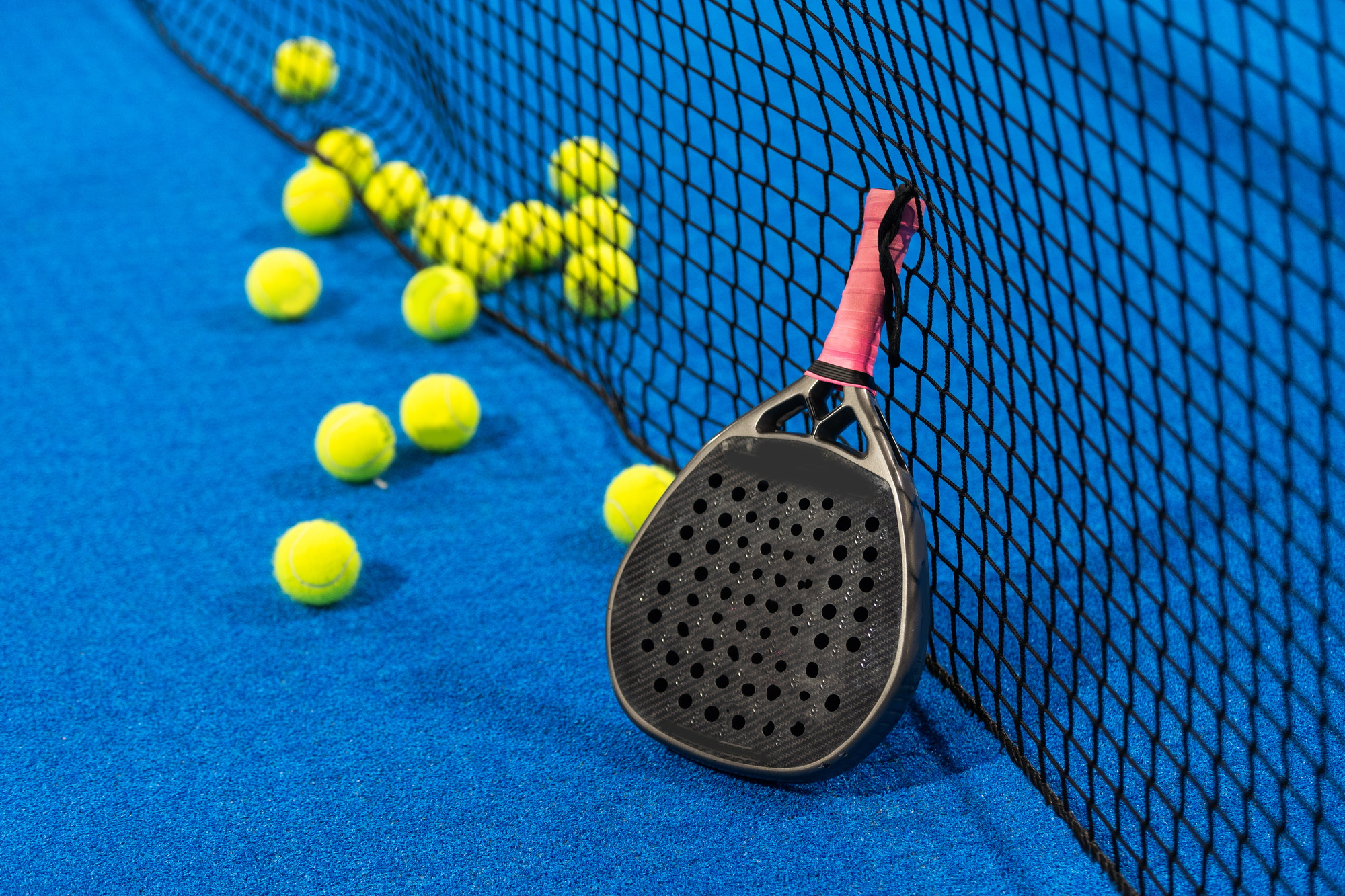 paddle tennis racket and balls on the blue paddle court